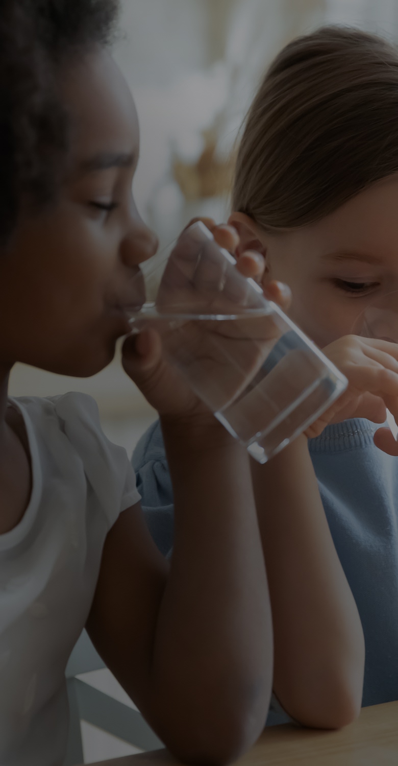 Children drinking water may unknowingly ingest microplastics from contaminated sources.