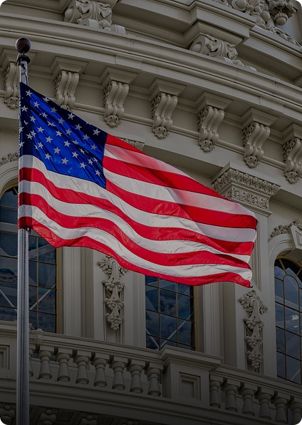 American flag waves in front of the Capitol, symbolizing a call to action for better recycling systems.