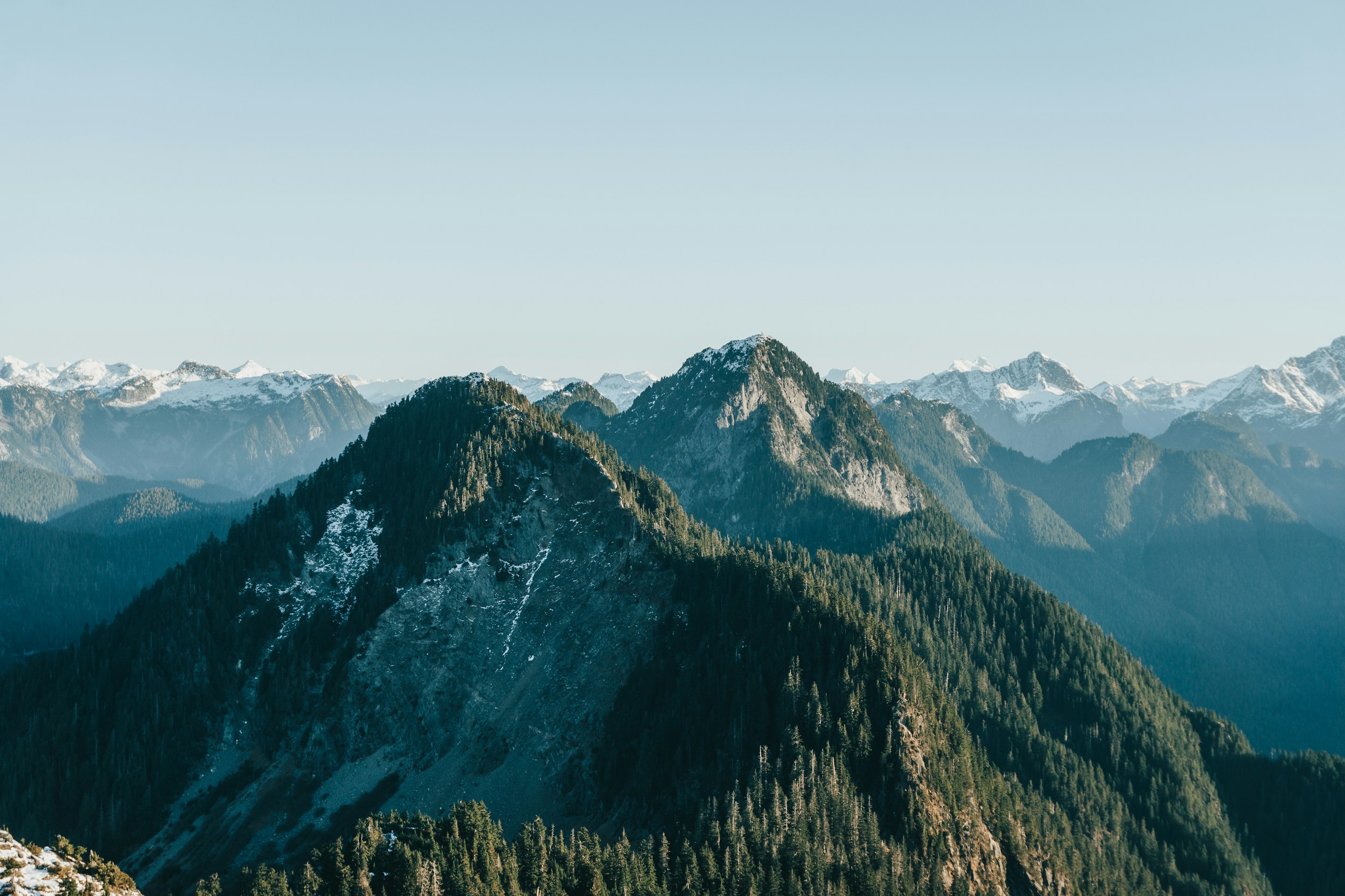 Beautiful green forests covering the mountain peaks in British Columbia, a leader in recycling.